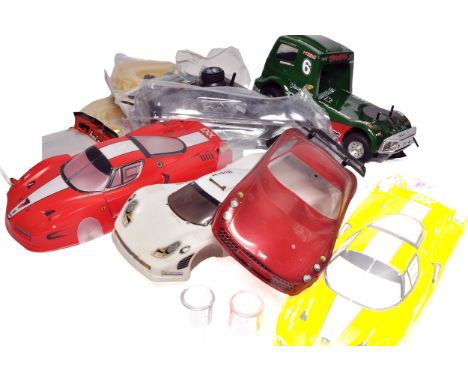 A lot of RC car bodies and accessories including body shells as shown. Includes a green racing truck shell and chassis, addit