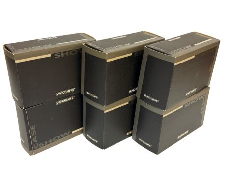 A group of six Minichamps branded display cases, each in individual black and silver packaging.