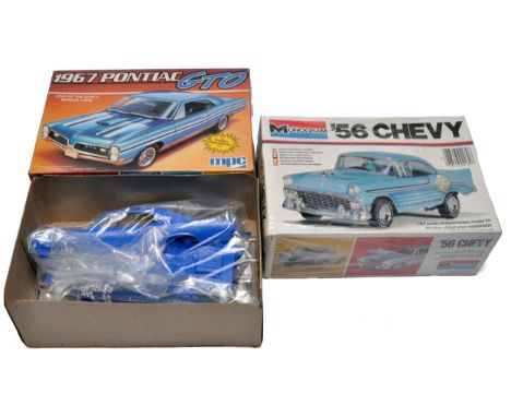 A duo of unassembled plastic car model kits including an MPC 1/25 scale 1967 Pontiac GTO (parts bagged in opened box) and a M