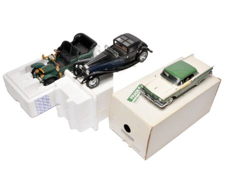 group of three die-cast model cars including a 1957 Ford Fairlane 500 Skyliner, a vintage open-top motorcar with brass detail