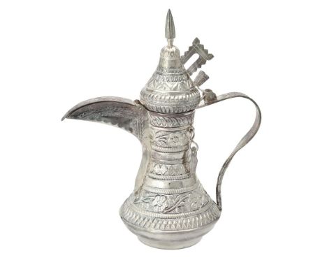 An Omani silver coloured tea pot, 20th century, stamped 925, with a coned finial to the domed cover, a scroll handle, chased 