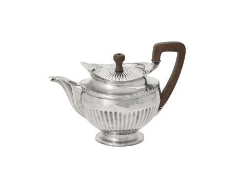 A Dutch silver half fluted circular tea pot, circa 1815, with a wooden finial and angular handle, a reeded band and on a circ