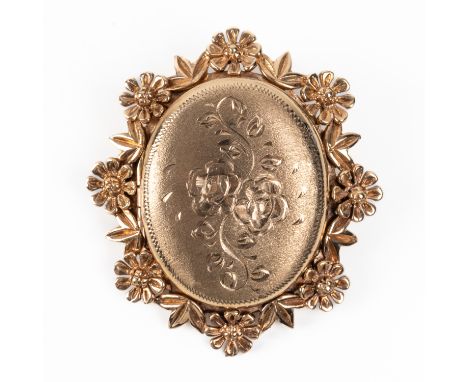 A 9CT GOLD OVAL LOCKET BROOCHOf shaped oval form, decorated with a floral border and engraved with a floral spray to the fron
