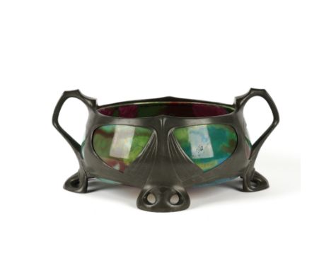 OSIRIS: A GERMAN ART NOUVEAU PEWTER AND CERAMIC MOUNTED TWIN-HANDLED JARDINIERECirca 1900 
With mottled reds, greens and blue
