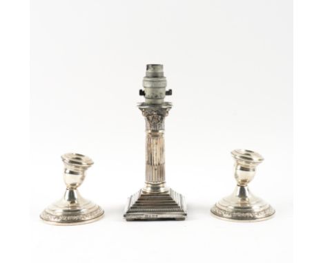 A SILVER CANDLESTICK CONVERTED TO A SMALL TABLE LAMP AND A PAIR OF STERLING CANDLESTICKS (3)The lamp formed from a Corinthian