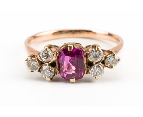 A GOLD, DIAMOND AND SYNTHETIC RUBY RINGClaw set with the cushion shaped synthetic ruby between round brilliant cut diamond th