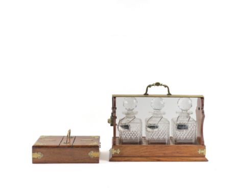 THE TANTALUS; A 19TH CENTURY BRASS BOUND OAK THREE BOTTLE TANTALUS (2)41cm wide; 16cm deep; 33cm high, together with a simila