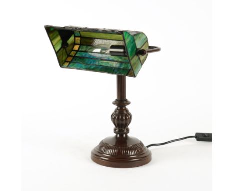 A TIFFANY STYLE GLASS MOUNTED METAL DESK LAMPModern
With a dragon-fly shade enclosing a single light, on baluster support, 37