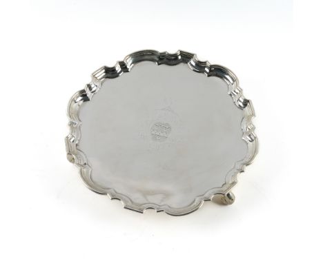 A GEORGE II SILVER SHAPED CIRCULAR SALVERHaving a Chippendale style pie-crust rim, raised on three scroll feet, armorial engr