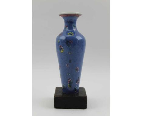 A Chinese porcelain vase of slender tapering form, blue glaze enameled flowers in colours pink, yellow, green, it has an ungl