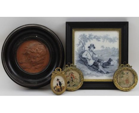 A framed terracotta roundel of a girls face, incised monogram, 9.5cm in diameter, together with a framed tile, a pair of bras