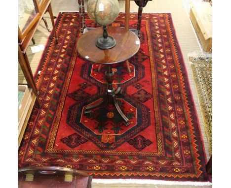 A woven woollen Persian carpet from Luri, having a trio of octagonal central motifs and a stylised multi-guard border, 161 x 