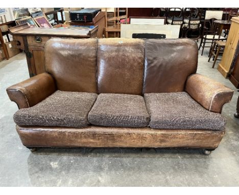 A 1930s leather upholstered sofa with a pair of matching armchairs. Distressed.
