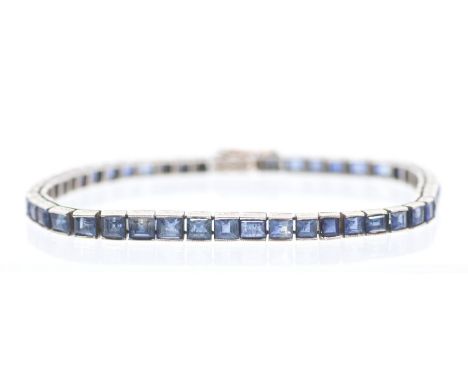 A sapphire and white gold tennis bracelet, comprising car set articulated links each set with a square cut sapphire, each app