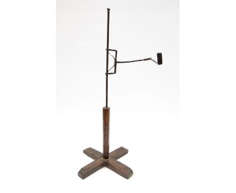 An 18th Century wrought iron rush light, with cross shaped wooden base, retractable arm. Approx. 80cm high and approx. 36cm f