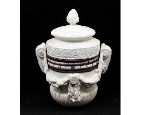 Georgian table or pedestal clock. Contained in a white ceramic urn decorated with swags and a pineapple finial. Numerals and 