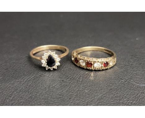 TWO GEM SET NINE CARAT GOLD RINGSone a sapphire and CZ cluster and the other a garnet and CZ half eternity ring, ring sizes K