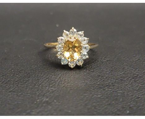 PRETTY CITRINE AND BLUE TOPAZ CLUSTER RINGthe central oval cut citrine measuring approximately 1ct, with a twelve blue topaz 