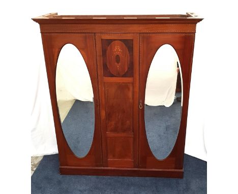 EDWARDIAN MAHOGANY AND INLAID WARDROBEwith a moulded cornice above a central panel with inlaid decoration, flanked by two ova