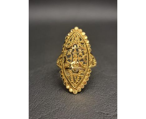 UNMARKED HIGH CARAT GOLD STATEMENT RINGthe marquise shaped ring with decorative bead and scroll work within a pierced design,