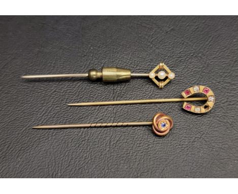 THREE GOLD TOPPED STICK PINSone set with seed pearls in fifteen carat gold, one with a paste set nine carat gold horseshoe, a