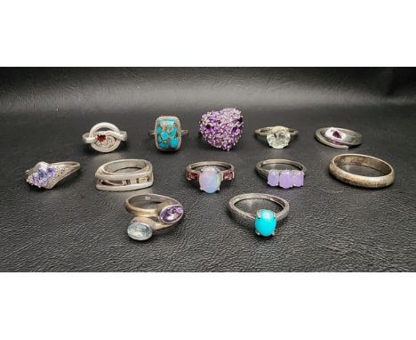 SELECTION OF TWELVE SILVER RINGSincluding a shaped Malcolm Gray example, an amethyst and blue topaz twist ring, and others se