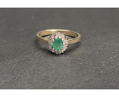 PRETTY EMERALD AND DIAMOND CLUSTER RING the central oval cut emerald measuring approximately 0.2cts, with a ten diamond surro