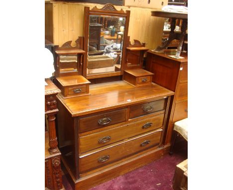 An Edwardian walnut dressing chest, the superstructure with swing bevelled mirror. On supports with mirror backs, small brack