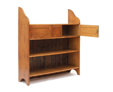 An Heal's-style oak open bookcase, with a shelf over two cupboards flanking a central panel, over two further shelves, and wi