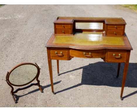 EDWARDIAN INLAID MAHOGANY BOWFRONTED WRITING TABLE WITH 4 DRAWERS FLANKING A BEVELLED MIRROR ABOVE 3 FRIEZE DRAWERS, ON TAPER