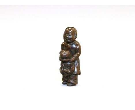 A fine wood Netsuke of a Karako holding a dogJapan, Edo period (1603-1868) early 19th centuryCarved standing wearing long rob
