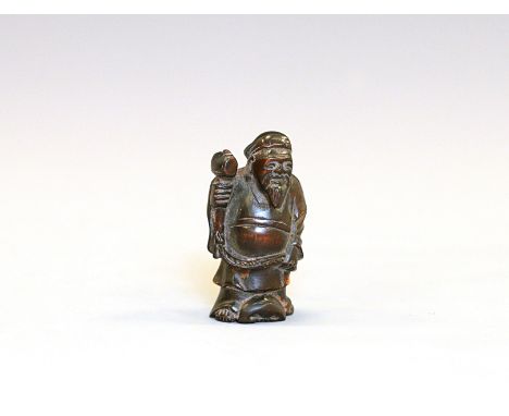A wood Netsuke of Daikoku holding Uchide-no-KozuchiJapan, Edo period (1603-1868) 19th centuryCarved standing wearing long rob
