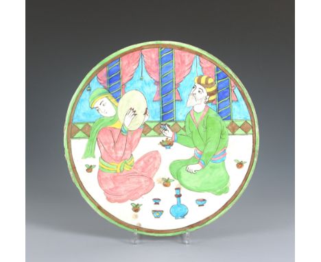 Oval ceramic tile with male and female, Persia, 19th century ADAn oval ceramic tile decorated with a seated elderly male wear