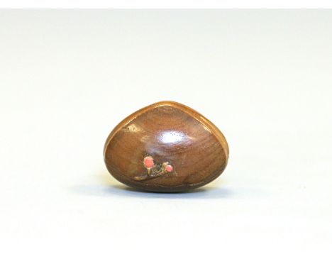 A wood netsuke with Shibayama-style inlayJapan, 19th centuryCarved into the shape of a chestnut with red coral inlay.Length 4
