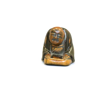 A rare wood and lacquer Netsuke with movable headJapan, Edo period (1603-1868) early 19th centuryCarved kneeling wearing long