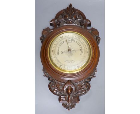 James Lucking &amp; Co. A carved mahogany aneroid barometer, length 46cm