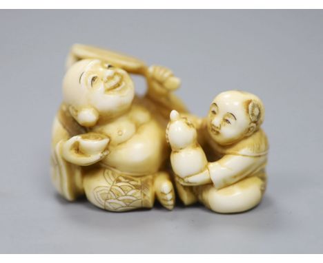 A Japanese ivory netsuke in the form of a seated Hotei and attendant, early 20th century 3cm high, 5cm wide, signed to unders