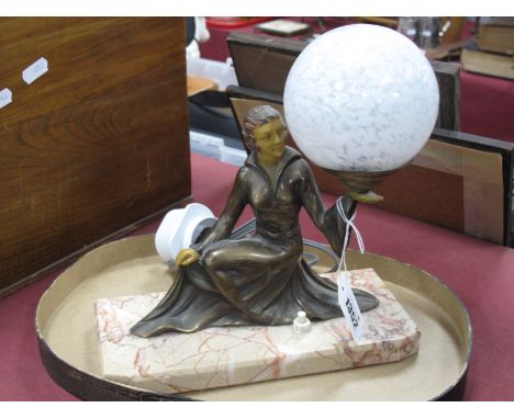 An Art Deco Table Lamp, as a lady seated, supporting the white mottle globe shade on her hand, on marbled base, 23.2cm wide (