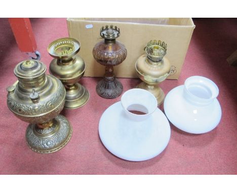 The Miller lamp of U.S.A, in embossed brass, two other brass and one glass oil lamp, two white shades, funnel.
