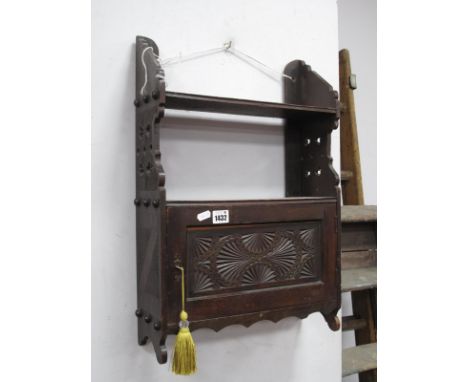 Late XIX Century Stained Beech Wall Rack, having single shelf over carved cupboard door, carved and pierced sides, 40cm wide.