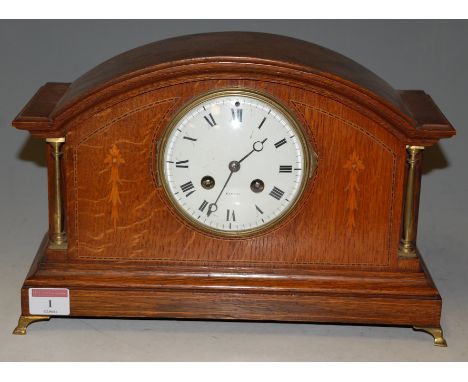 An Edwardian oak and satinwood inlaid mantel clock, of architectural form, having enamel dial with Roman numerals, eight day 