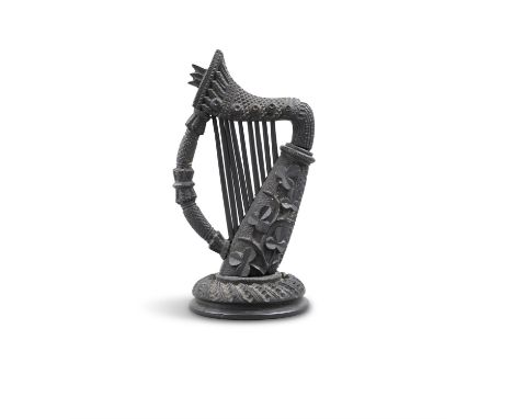 A 19TH CENTURY CARVED BOG OAK MODEL OF A HARP, profusely carved with shamrocks, crosshatching on a carved circular base. 17cm