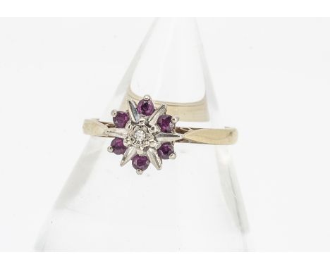 An 18ct gold diamond and ruby dress ring, the illusion set eight cut diamond surrounded by eight round cut rubies, in a star 