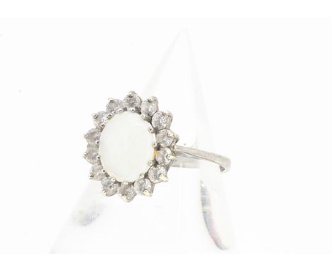 A 9ct gold opal and white stone set cluster ring, the oval cabochon in claw setting surrounded by white stones all in white 9