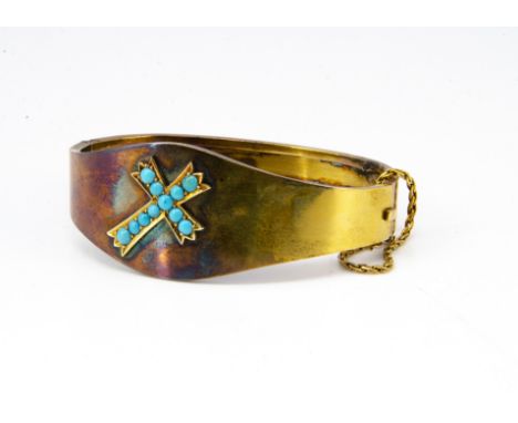 An Edwardian yellow metal and turquoise bangle, the ovoid hinged top with central decoration of turquoise beads in the form o