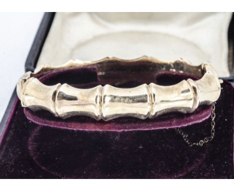 A 9ct gold bamboo effect hinged bangle, with box clasp and safety chain, 6cm x 5.5cm, 15g, boxed 