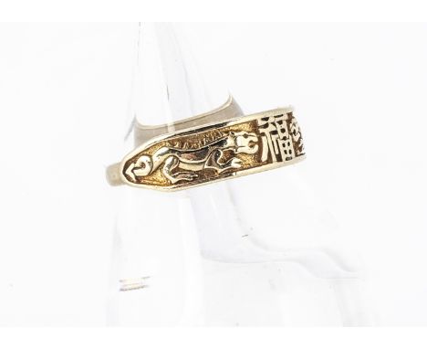 A contemporary 9ct gold dress ring, with central decoration of a pair of dragons either side of a Chinese seal, ring size S, 