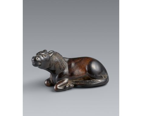 Netsuke eines großen liegenden Hengstes. Wahrscheinlich Kaki-Holz. 19. Jh.Den Kopf wenig zur Seite gewandt und weit vorgestre