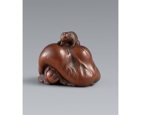 Netsuke eines tanuki und Jäger. Holz. Ise-Yamada. 2. Hälfte 19. Jh.Sign.: MasakazuDer Jäger wird von dem riesigen Skrotum ein