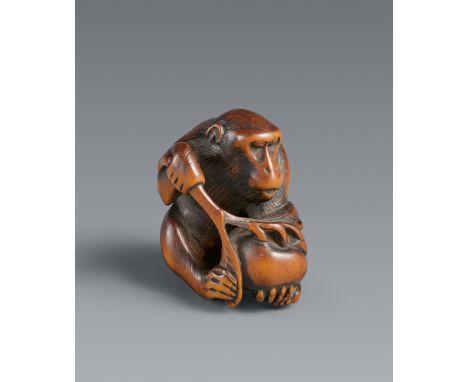 Netsuke eines Affens mit Pfirsich. Buchsbaum. Kyoto. Frühes 19. Jh.Sign. in ovaler Reserve: MitsuhideSitzend mit einem großen